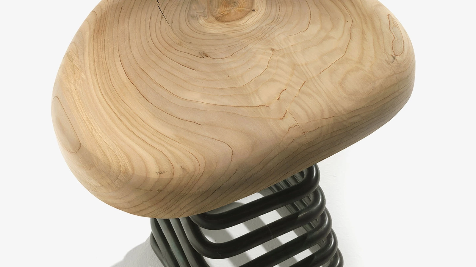 Sgabello Molla composto da un sedile sagomato in legno massello sorretto da una molla quadrata di Riva1920